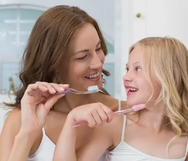 Madre e hija cepillándose los dientes