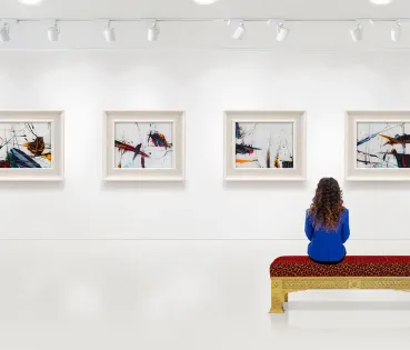 Mujer mirando obras de arte en un museo.